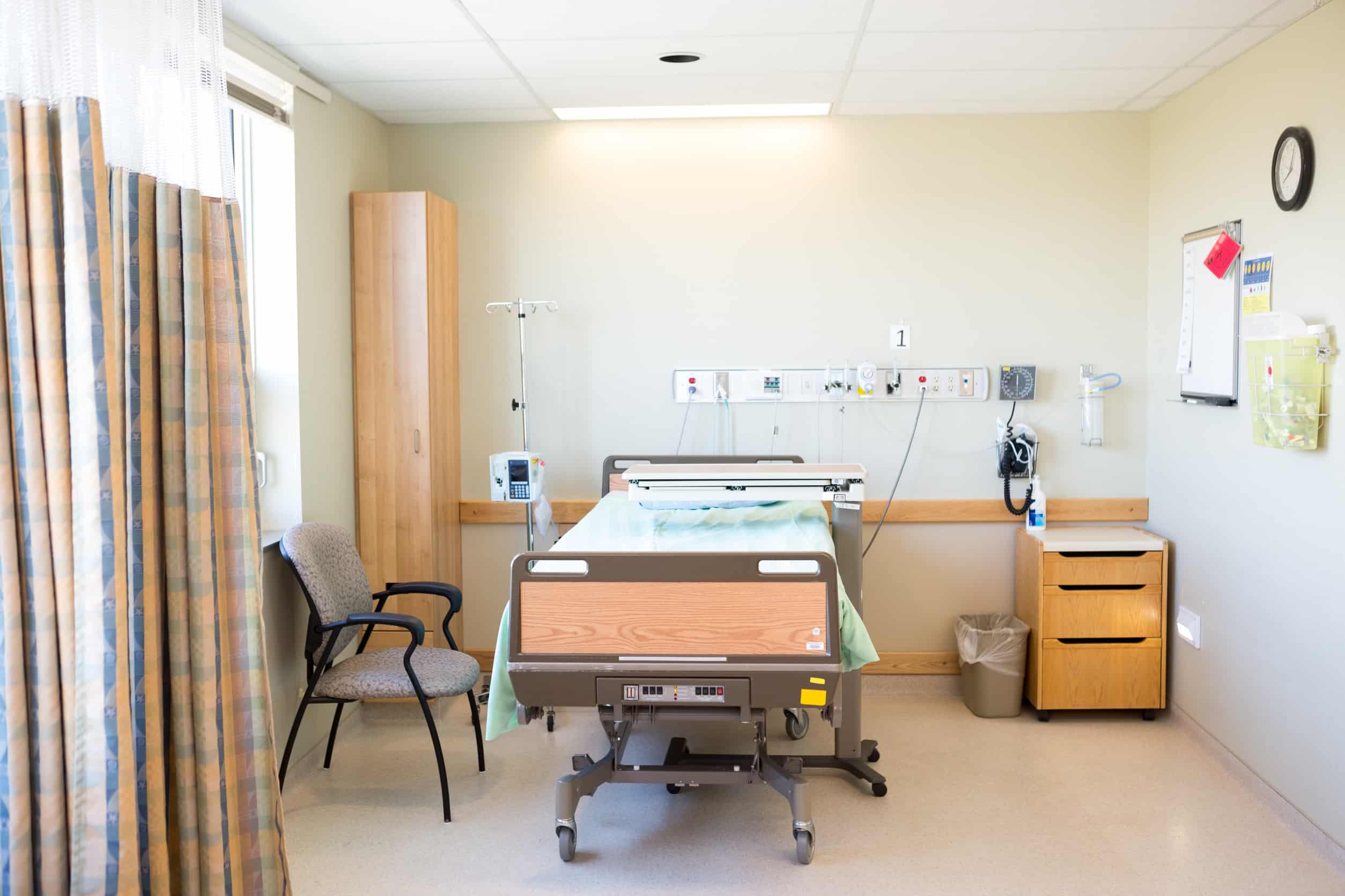 Interior of hospital room with bed and chair