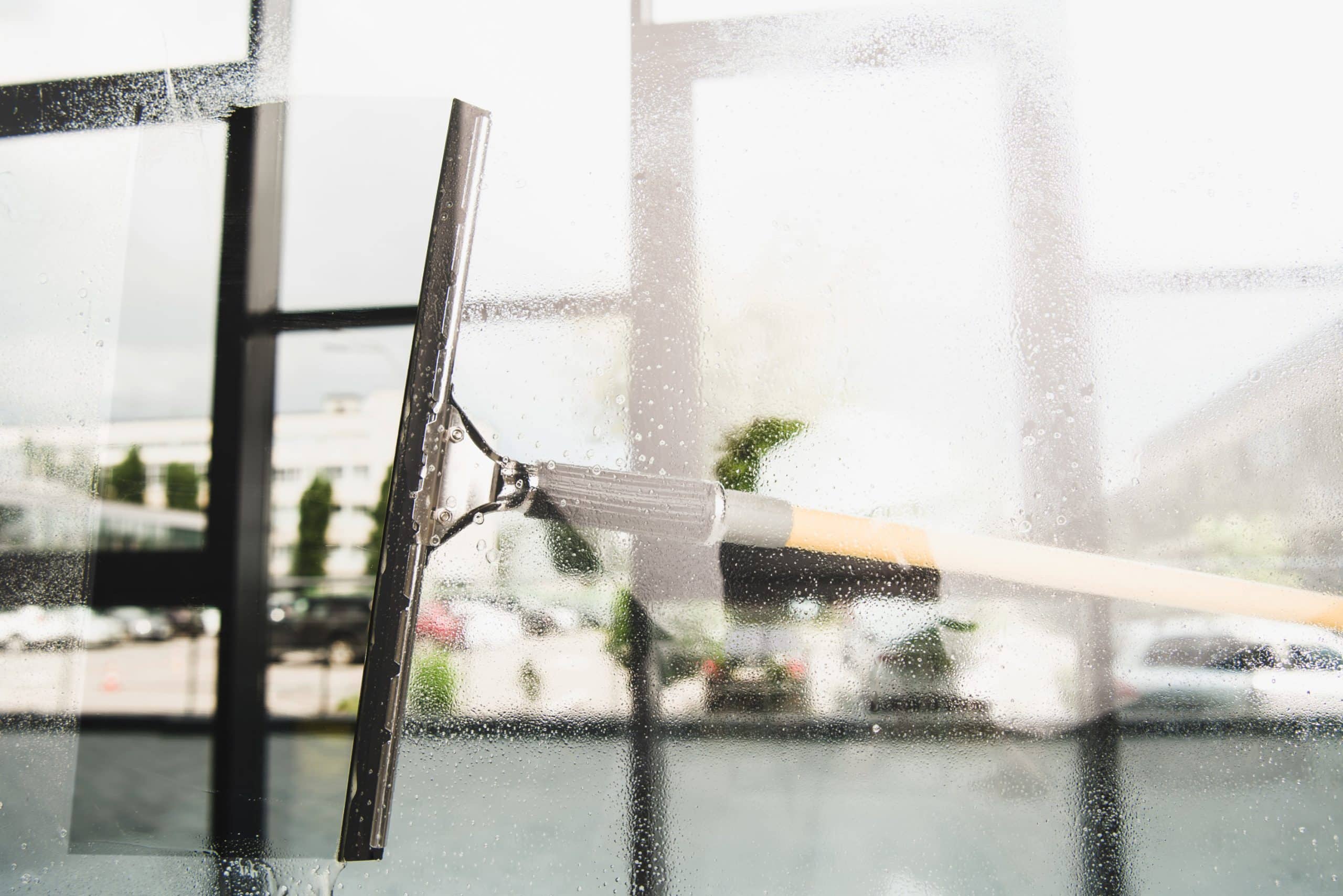 a large squeegee cleaning a window